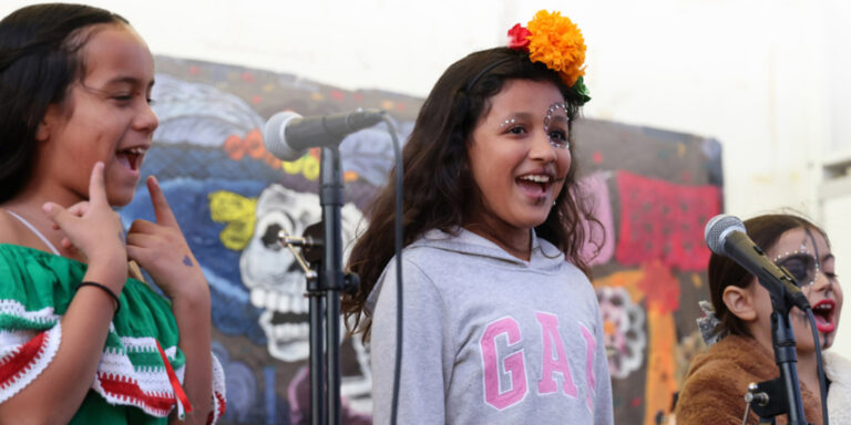 Boys and Girls Club of Broward county Members with their faces painted performing on stage.