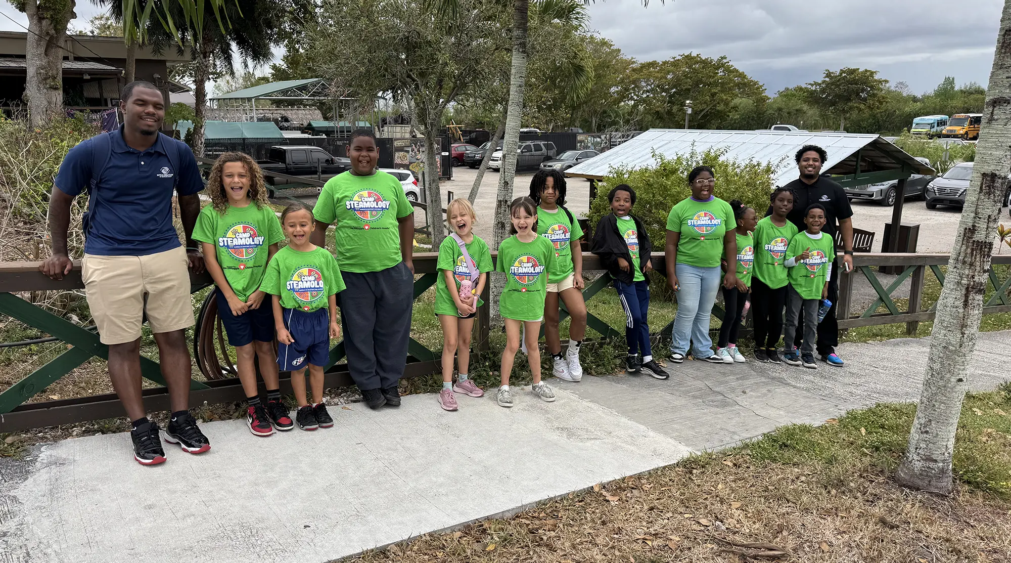 A group photo of the MODS BGCBC Club members and a staff member in the Everglades. The club members are all wearing 'Camp Stemology' shirts