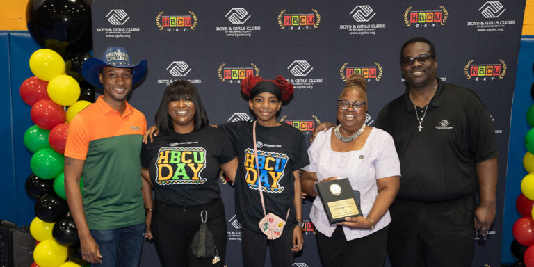 BGCBC staff members and a club member posing in front of a backdrop that features the Boys & Girls Clubs of Broward County and the acronym 'H B C U' for 'Historically Black Colleges and Universities'