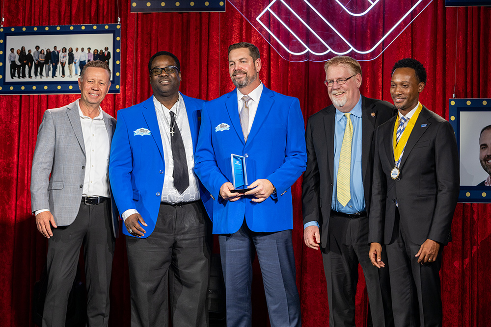 Rear Admiral Ryan M. Perry Posing with fellow Boys & Girls Clubs of Broward County hall of famers and BGCBC Board members with his Blue Door award. He and his fellow BGCBC Hall of fame honoree are wearing the blue BGCBC blazer.