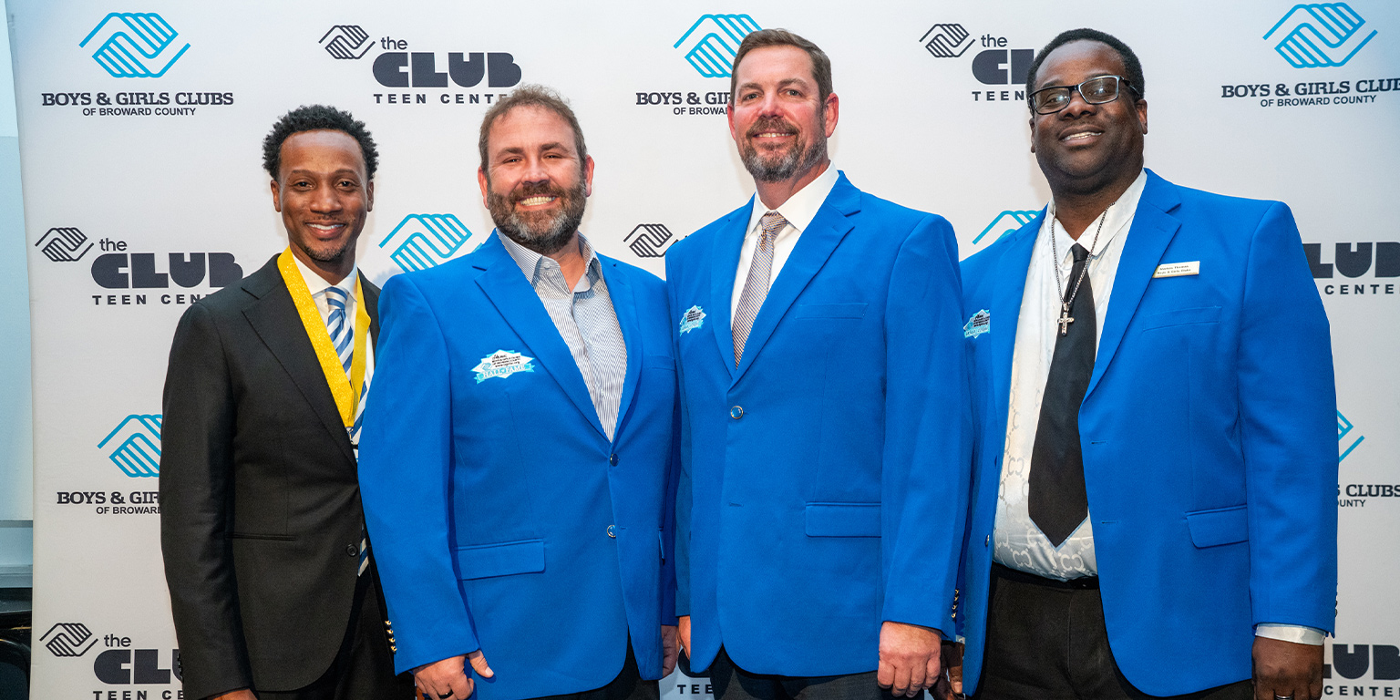 Rear Admiral Ryan M. Perry posing with two fellow Boys & Girls Clubs of Broward County hall of fame members along with BGCBC Staff.