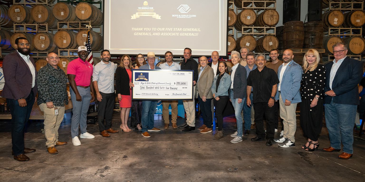 Doug Cady holding a massive check. Alongside him are community leaders who attended the General's Club gathering