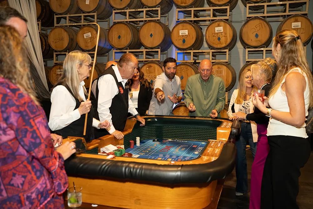 Attendees of the event playing a table game with croupiers running the game