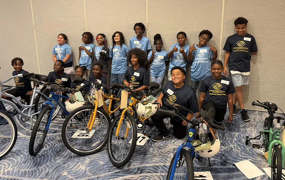 A group photo of BGCBC Club member attendees posing with the bikes they were able to take home