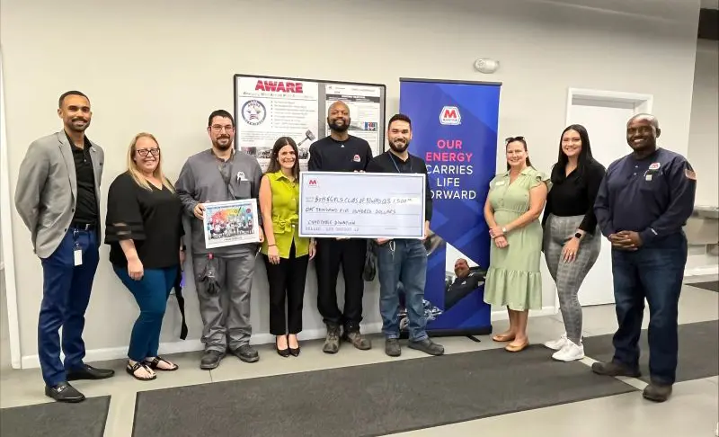 A group photo of the BGCBC's Cameron Warrick posing alongside Marathon Petroleum Corporation's staff. Marathon is presenting a large check to the Boys & Girls Club of Broward County.