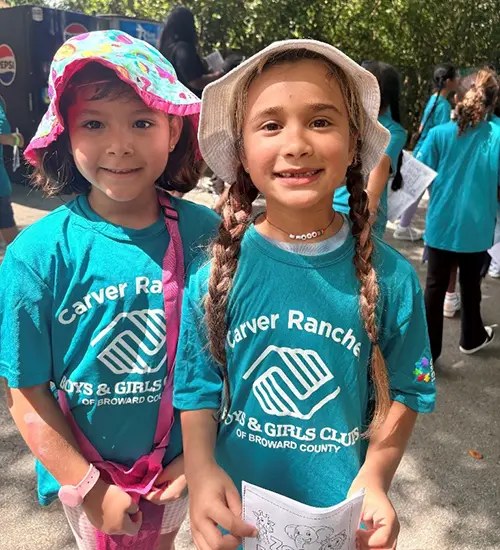 Two Boys & Girls Clubs of Broward County members on the zoo field trip smiling. They are both wearing blue BGCBC shirts