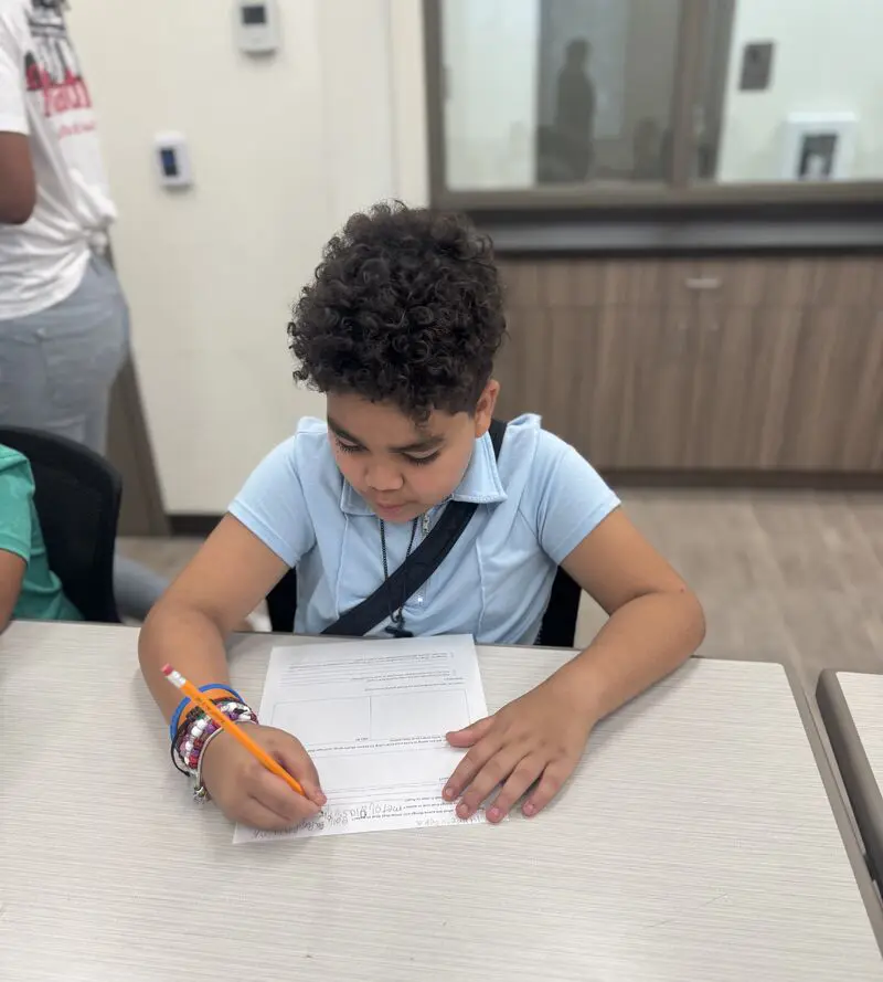 A BGCBC club member focused on filling out their worksheet