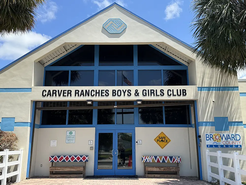 The white exterior with blue window frames of the Carver Ranches Boys & Girls Club of Broward County
