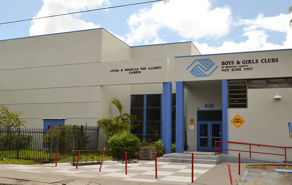 An exterior picture of the Nan Knox Boys & Girls Club. It's a white building with blue pillars around the entrance.